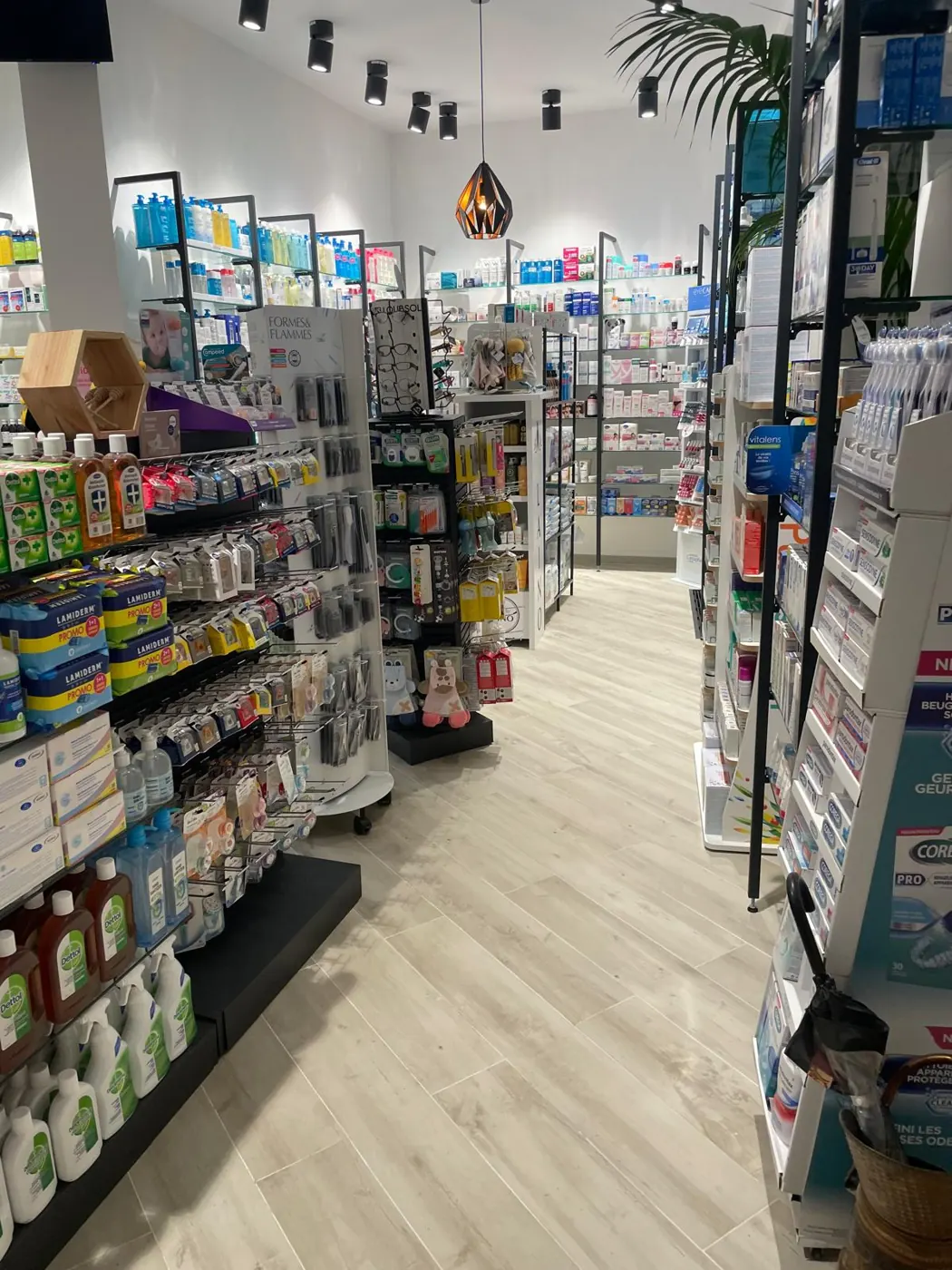Intérieur de pharmacie rénovée : allée, linéaires et éclairage
