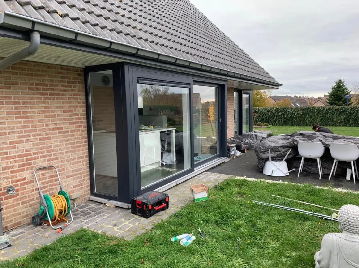 Baie coulissante et châssis d'angle anthracite posés sur une maison